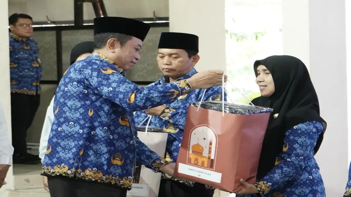 MERINGANKAN: Bupati Bondowoso, Abdul Hamid Wahid menyerahkan bantuan seragam dan beasiswa kepada perwakilan penerima manfaat.(PROKOPIM)
