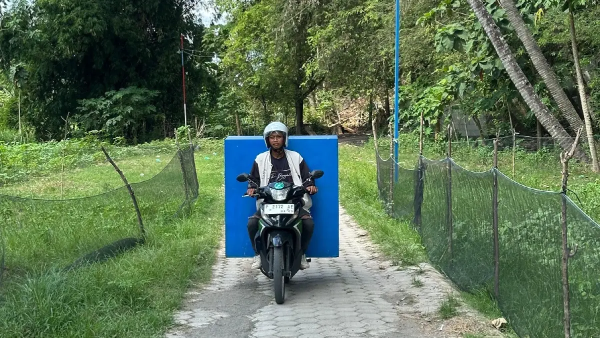 BERHATI-HATI: Frengky pengantar MBG saat melewati jalanan tak mulus area pelosok Desa/Kecamatan Klabang. (FAQIH HUMAINI/RADAR IJEN)