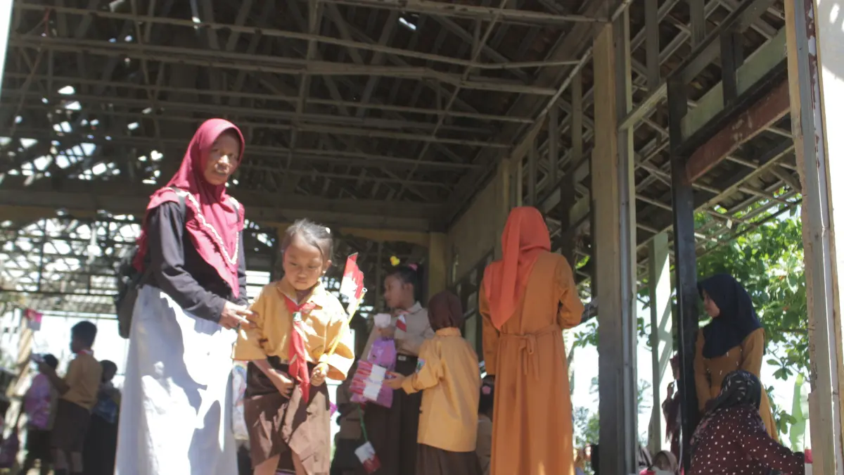 DIDAMPINGI: Orang tua siswa di Kecamatan Wringin, menjemput anaknya di sekolah. Sejumlah orang tua atau wali murid juga menantikan evaluasi terkait menu MBG yang dibagikan.(ILHAM WAHYUDI/RADAR IJEN)