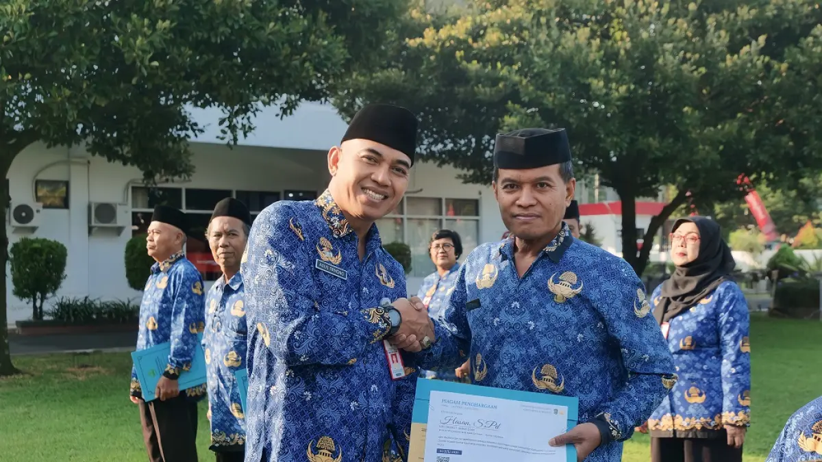 SAMPAIKAN PESAN: Sekretaris Daerah Agus Triyono saat memberikan penghormatan berupa piagam penghargaan kepada ASN yang bakal pensiun.(KOMINFO FOR RAME)