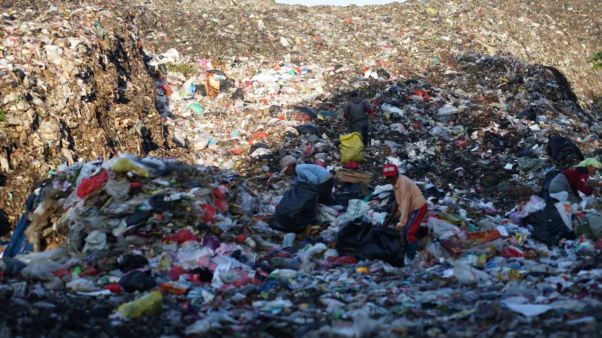 BERJUANG: Salah seorang pemulung di TPA Taman Krocok membawa hasil memulung sampah yang baru diturunkan oleh petugas.(ILHAM WAHYUDI/RADAR IJEN)