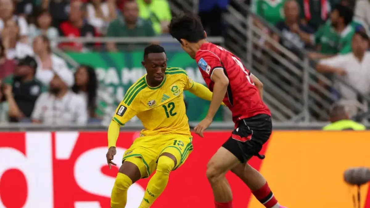 Penyerang Afrika Selatan, Thapelo Maseko, menguasai bola saat dibayangi oleh pemain Korea Selatan, Lee Gihyuk, dalam pertandingan sepak bola Grup A Piala Dunia 2026 antara Afrika Selatan dan Korea Selatan di Stadion Monterrey, Guadalupe, Meksiko, pada 24 Juni 2026. (AFP)