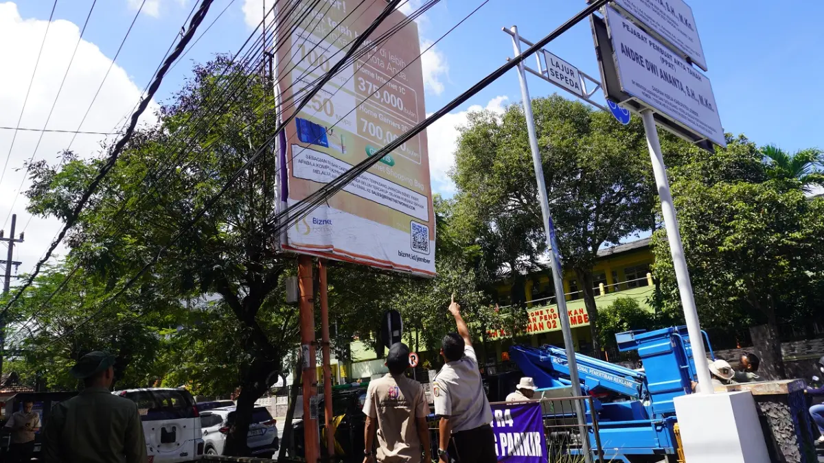 GANGGU ESTETIKA: Salah satu pemandangan kabel PLN, kabel jaringan telekomunikasi Wi-Fi, yang sesak jadi pemandangan di sekitar ruas Jalan A. Yani Jember kota. Di lokasi yang tidak jauh berbeda, penampakan yang sama terlihat lebih semrawut dan berjubel. (MAULANA/RADAR JEMBER)
