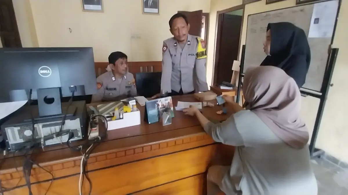 PELAYANAN TERGANGGU: Anggota Polsek Tempurejo tidak bisa melayani warga yang datang untuk minta surat laporan kehilangan karena listrik padam pada Jumat (26/6/2026) . (Jumai/radarjember)