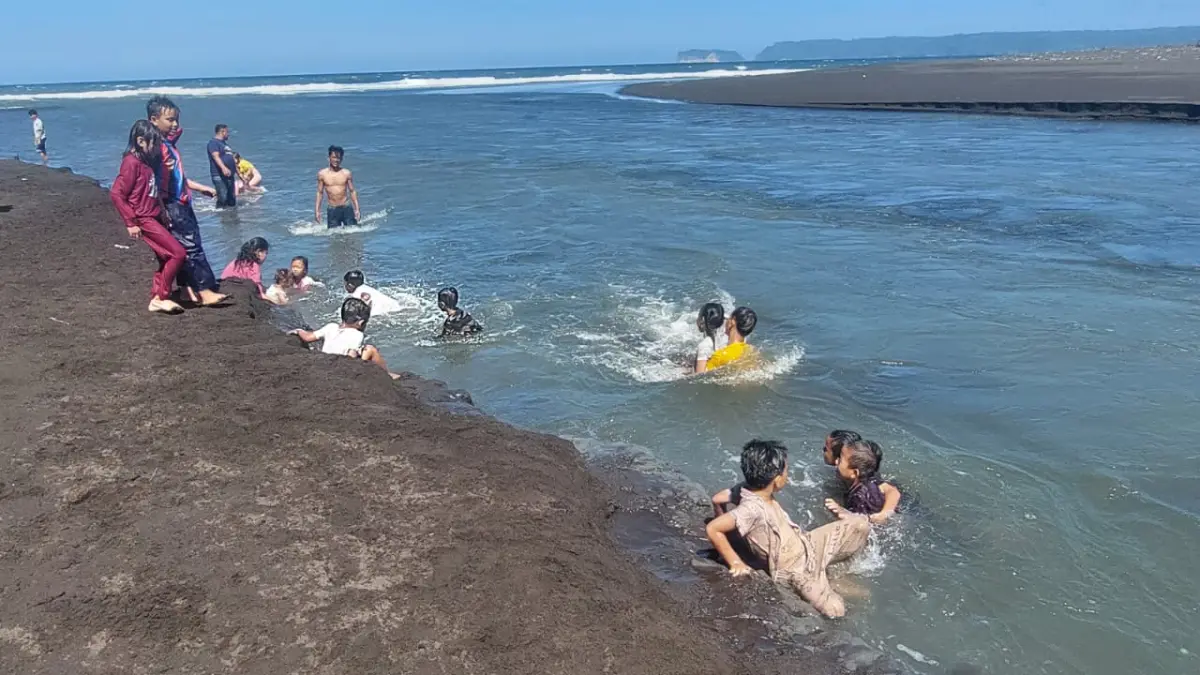 MASIH NEKAT MANDI: Puluhan anak yang masih nekat mandi di arus muara sungai di Pantai Cemara, Dudun Getem, Desa Mojomulyo, Kecamatan Puger, Jember pada Minggu (28/6/2026). (Jumai/radarjember)