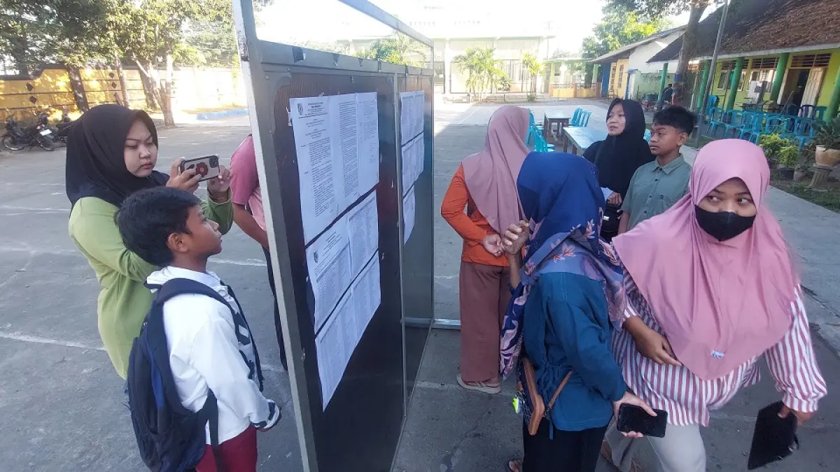 CEK PENERIMAAN: Kerumunan wali murid saat merangsek maju melihat papan pengumuman jalur zonasi di SMPN 1 Ambulu, kemarin (29/6) pagi. Sekolah di pusat kecamatan kebanjiran pendaftar hingga menolak ratusan siswa. (JUMAI/RADAR JEMBER)