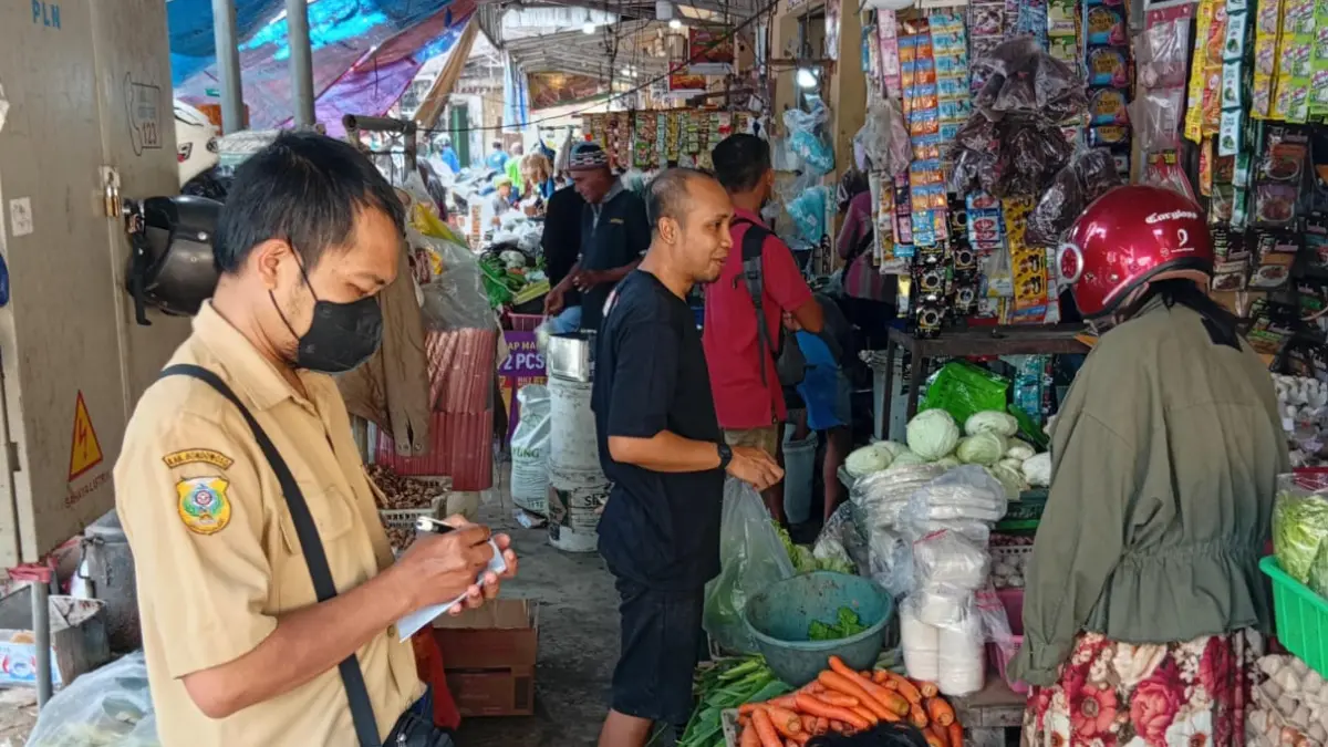 DIPANTAU: Sejumlah petugas Diskoperindag Bondowoso melakukan pemantauan harga bahan pokok di Pasar Induk Bondowoso. (ILHAM/RJ)