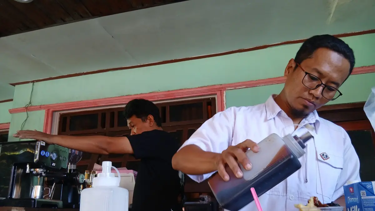 TELATEN: Ketua Komunitas Barista Class Bondowoso Ahmad Sofyan meracik es kopi tape. (ILHAM WAHYUDI/RADAR IJEN)