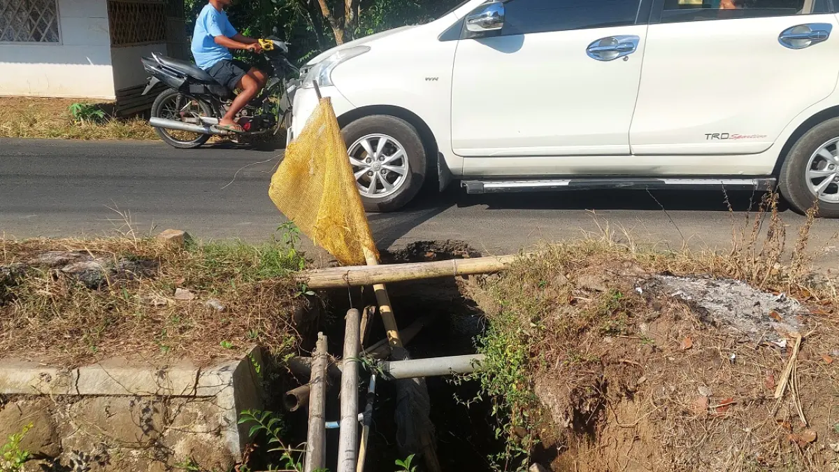 BAHAYA: Kondisi jalan penghubung Desa Kemungkin Lor dengan Desa Pakis, Kecamatan Panti terdapat yang ambrol dan hanya diberi tanda plastik. (JUMAI/RADAR JEMBER)