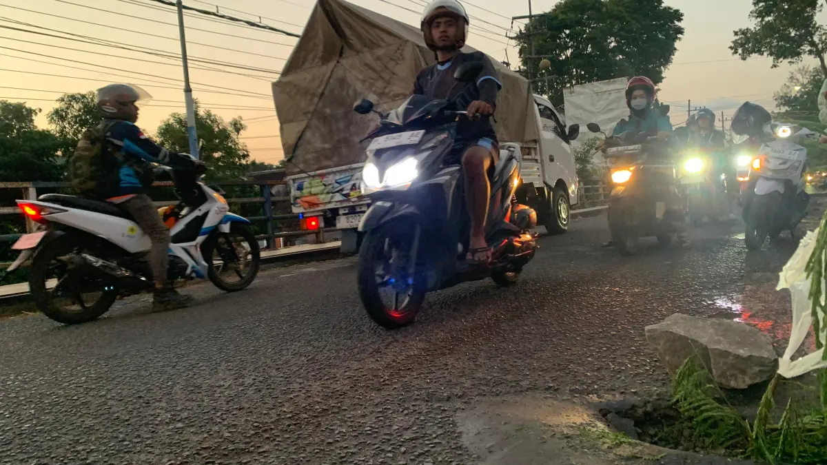 BERLUBANG: Sejumlah pengendara melintas di Jembatan Koncer yang berlubang. (ILHAM/RJ)