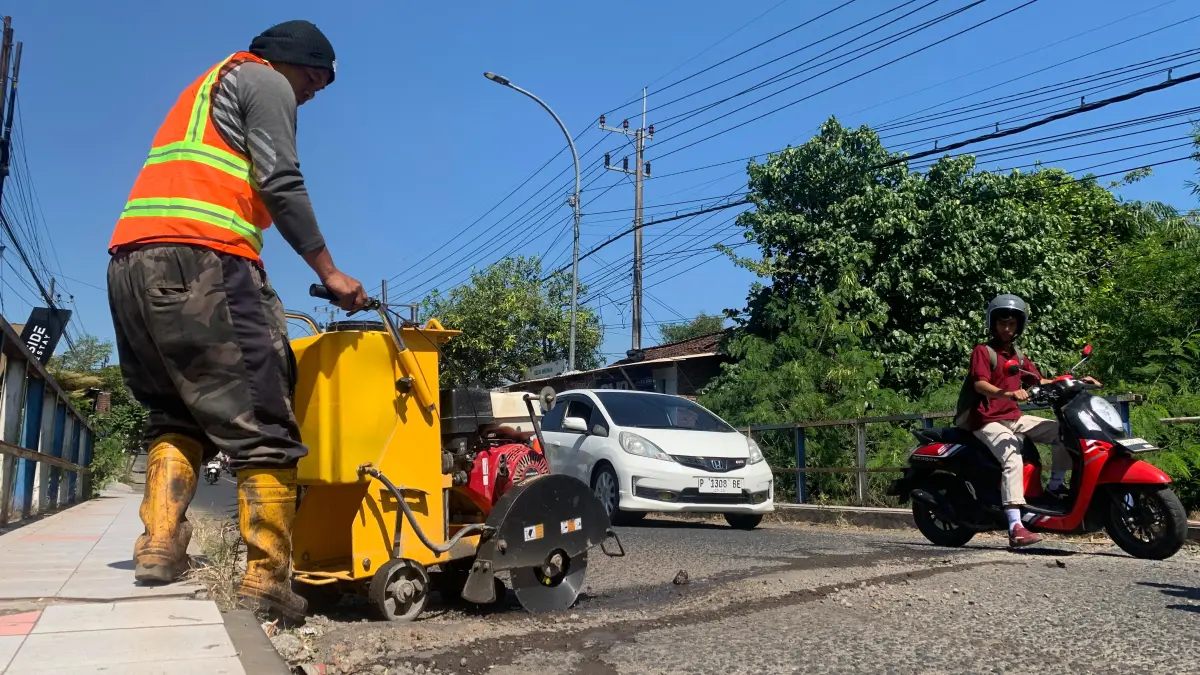 DIPERBAIKI: Petugas BSBK Bondowoso berupaya memperbaiki Jembatan Koncer yang berlubang dan dikeluhkan oleh warga. (ILHAM/RJ)