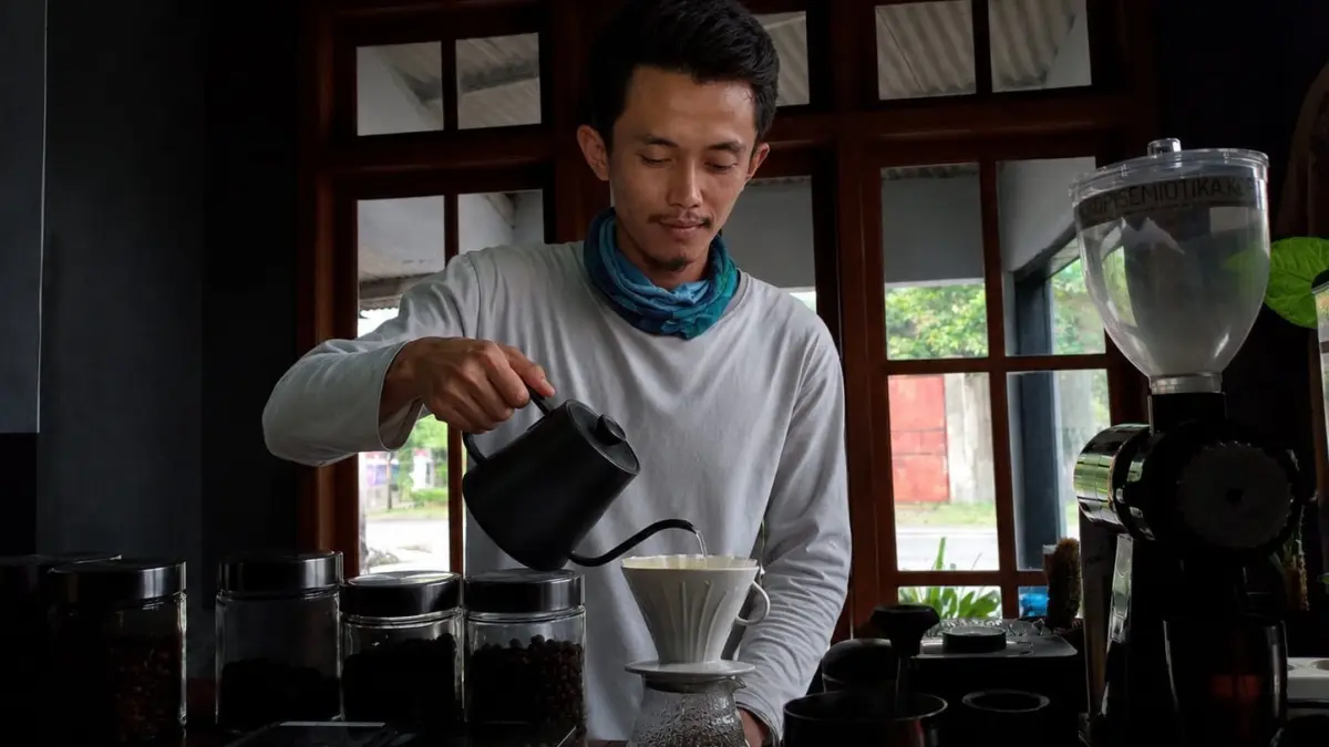 OLAH KOPI : Dimas, pemuda asal Kecamatan Panti menyeduhkan kopi siap di seruput. (M. ADHI SURYA/RADAR JEMBER)
