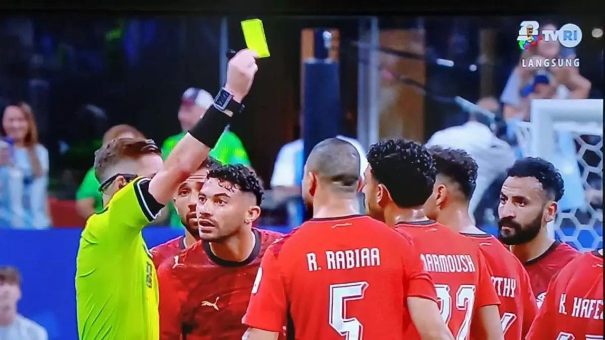 Wasit Francois Letexier saat memberikan kartu kuning kepada pemain Mesir
