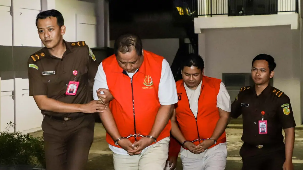 MERUGIKAN NEGARA: Dua tersangka kasus dugaan korupsi penyelewengan dana KUR BNI Cabang Jember, berinisial AM dan IS, saat digiring oleh tim penyidik Kejaksaan Tinggi Jawa Timur pada Rabu (8/7/2026) malam. Sementara itu, satu tersangka utama lainnya, yakni MFH, saat ini ditahan secara terpisah di Lembaga Pemasyarakatan (Lapas) Kelas IIA Kabupaten Jember untuk menjalani proses hukum lanjutan. (ALFIAN RIZAL/JAWA POS)