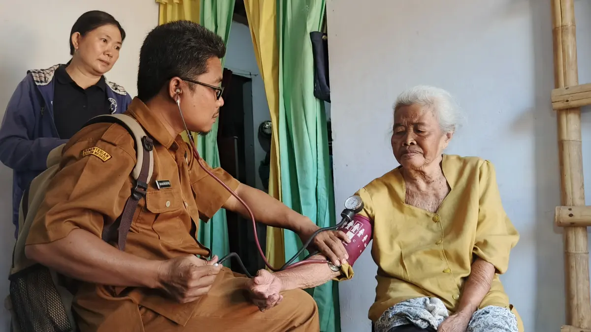 Salah satu petugas Puskesmas Ambulu dan Kader Posyandu, saat mengunjungi kediaman seorang lansia, di Dusun Sentong, Desa Karanganyar, Kecamatan Ambulu, untuk dilakukan pemeriksaan kesehatan, (13/7/2026). (Maulana/JPRJ)
