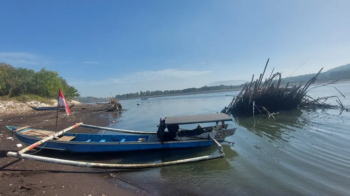 TERGANGGU: Tumpukan bambu di muara Sungai Bedadung, kawasan Plawangan Puger, mengganggu aktivitas nelayan saat memarkir maupun mengeluarkan jukung. (JUMAI/RADAR JEMBER)