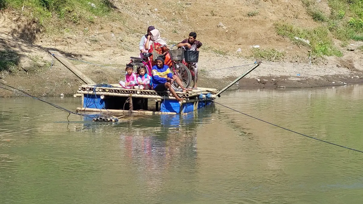 BUTUH JEMBATAN: Para ibu-ibu yang mengantarkan anak sekolah PAUD dengan sepeda kayuh kini sepedanya bisa naik gethek rakitan untuk menyebrang Sungai Bedadung. (JUMAI)
