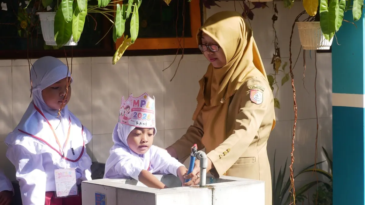 UNTUK SISWA: Guru di SDN Kebonsari 04 mengajarkan anak-anak tentang pentingnya mencuci tangan pada kegiatan MPLS. (SIDKIN ALI/RADAR JEMBER)