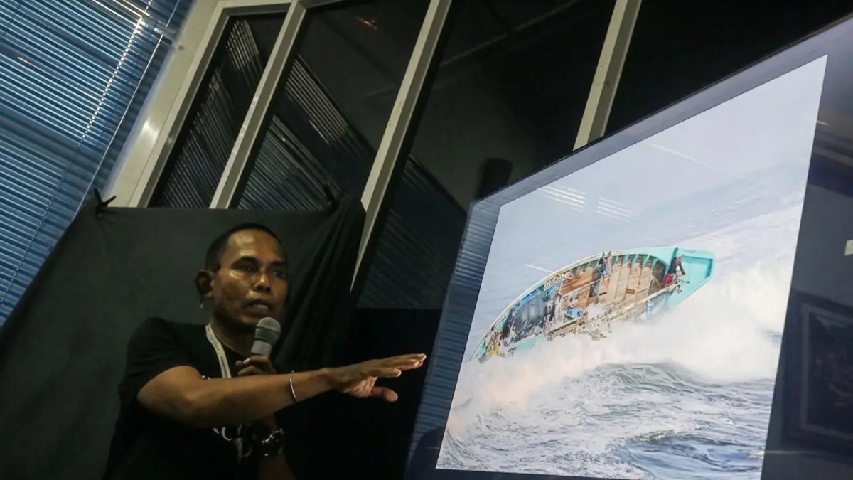 BERCERITA: Fotografer senior Radar Jember, Jumai, menceritakan proses mendapatkan detik-detik kapal terbalik dihantam ombak Plawangan, Puger pada Juli 2018 lalu. (DWI SISWANTO/RADAR JEMBER)