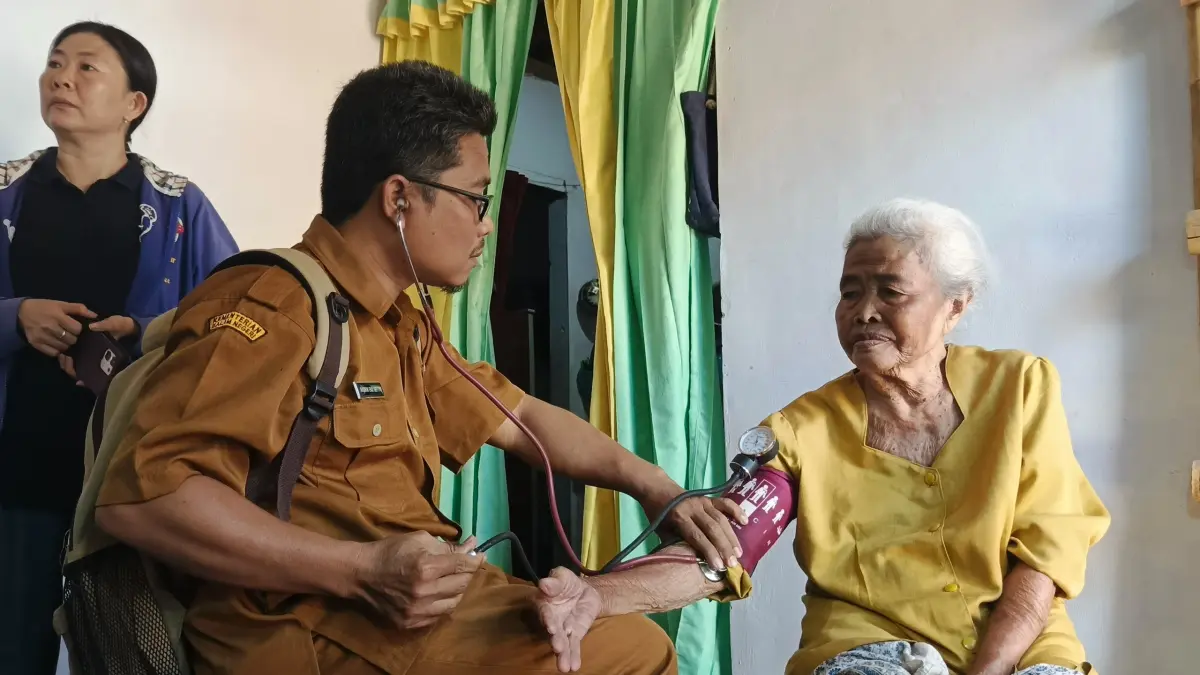 Salah satu nakes bersama kader Posyandu Puskesmas Ambulu, saat turun ke rumah seorang lansia untuk memberikan pemeriksaan kesehatan, belum lama ini, (13/7). (Maulana/JPRJ)