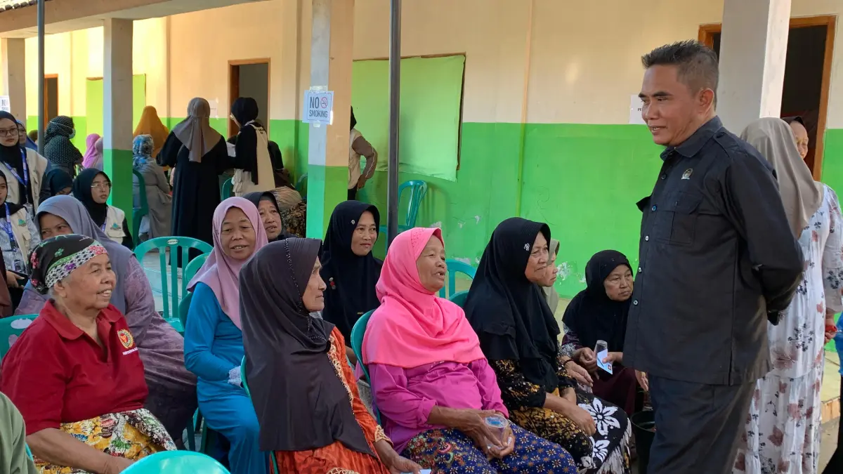 RAMAH: Anggota Fraksi PKB Bondowoso, A Mansur menyapa warga yang menunggu giliran pemeriksaan kesehatan. (ILHAM/RJ)
