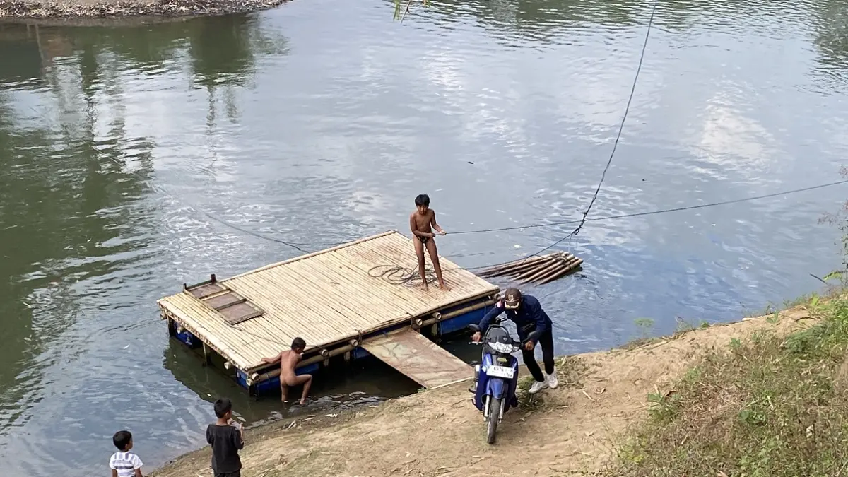 FUNGSI GANDA: Getek rakitan berbahan bambu dan drum plastik di Sungai Bedadung, Dusun Darungan, Desa Jubung, Kecamatan Sukorambi, tidak hanya dimanfaatkan pejalan kaki. Tetapi juga dapat digunakan untuk menyeberangkan motor. (JUMAI/ RADAR JEMBER)