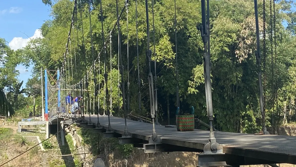 TINGGAL FINISHING: Setelah pemasangan lantai rampung, jembatan gantung sepanjang 105 meter di Dusun Darungan, Desa Jubung, Kecamatan Sukorambi, kini sudah tersambung. (JUMAI/RADAR JEMBER)
