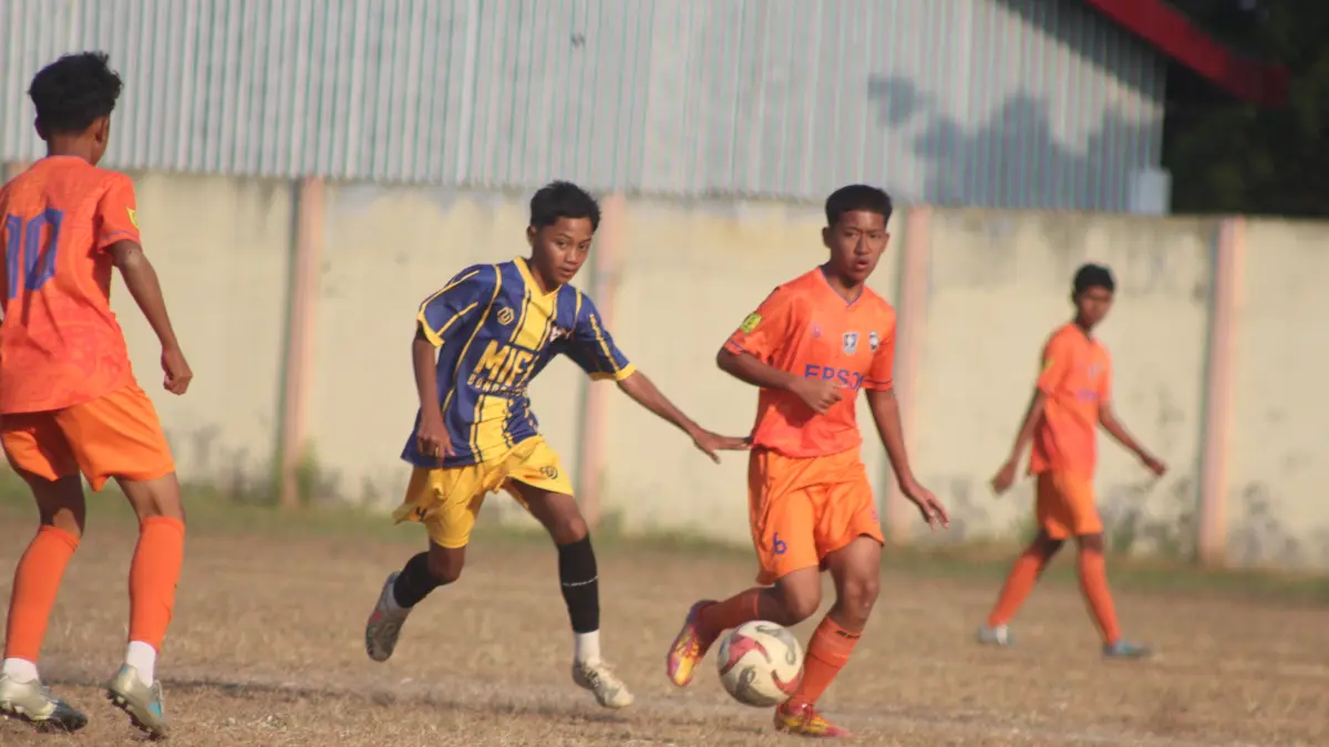 BERDUEL: Pemain Arseko (orange) dan pemain Mifa Academy (biru) sama-sama ngotot untuk mendapatkan dan menguasai bola liar, saat final Piala Soeratin U-15.