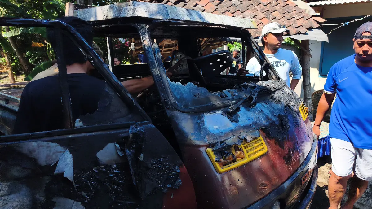 HANGUS:Petugas dan warga dan memadamkan sisa api yang membakar sebuah rumah

