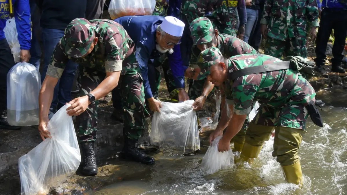PELESTARIAN LINGKUNGAN: Tim gabungan antara personil Kodim 0824 Jember bersama relawan, santri dan mahasiswa resik-resik sungai Bedadung di Kelurahan Baratan, Kecamatan Patrang. (M. ADHI SURYA/RADAR JEMBER)