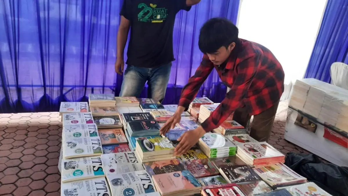 MELIHAT: seorang warga saat melihat buku-buku yang ada Disperpusip beberapa waktu lalu. (FAQIH/RJ)