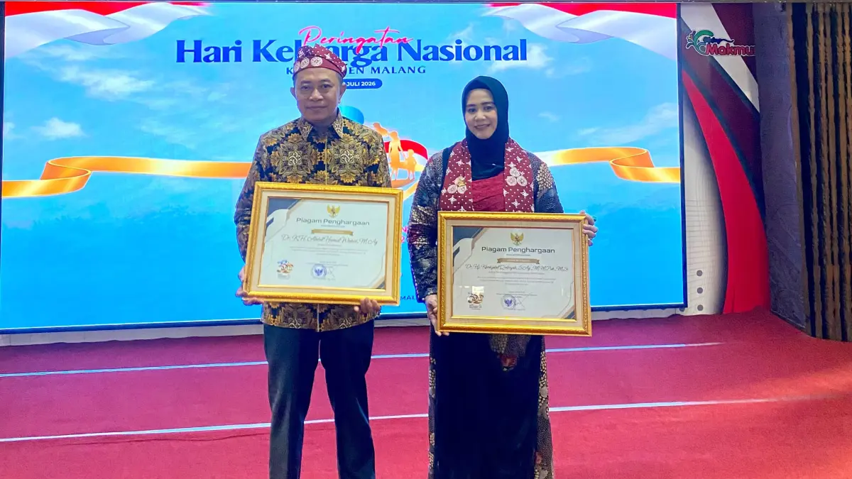 Bupati Bondowoso, Abdul Hamid Wahid (kiri) bersama istrinya menerima penghargaan dalam rangka hari keluarga nasional.
