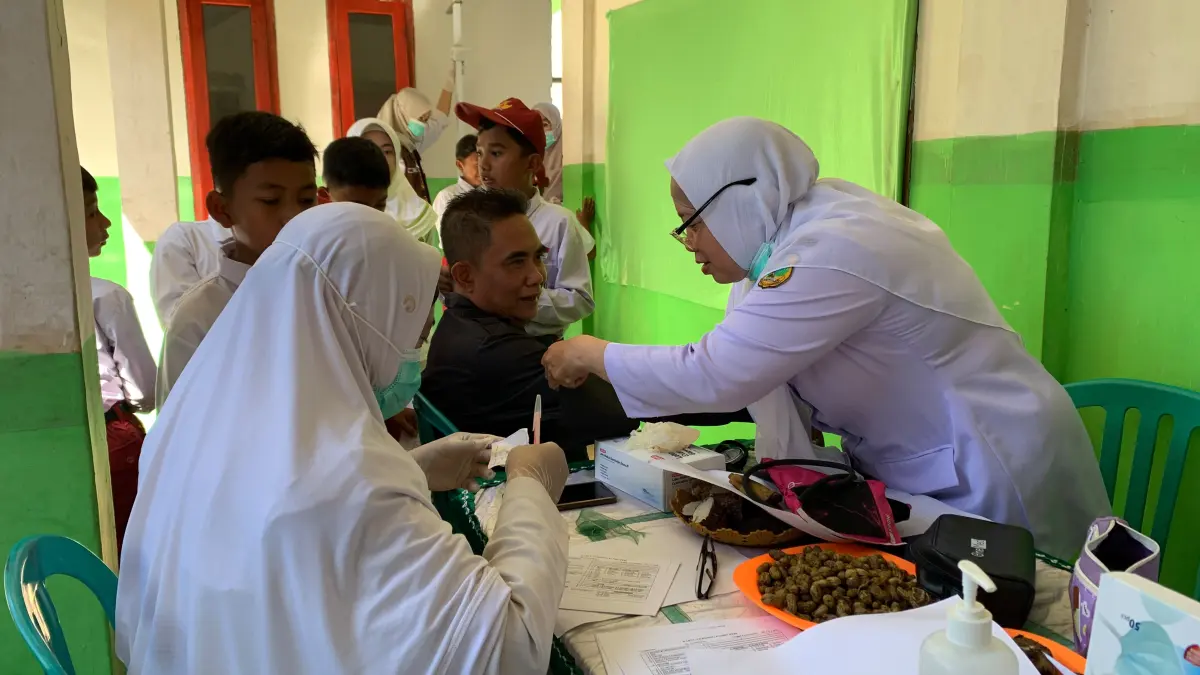 TELITI: Salah seorang petugas kesehatan di Bondowoso melakukan pemeriksaan kesehatan warga beberapa waktu lalu.(ILHAM WAHYUDI/RADAR IJEN)
