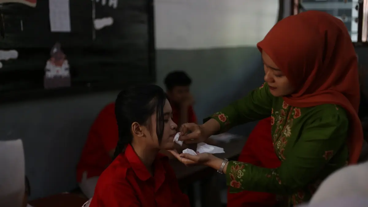 PENERTIBAN: Guru BK SMK Kartini mengontrol rias wajah siswi yang berlebihan selama aktivitas belajar di sekolah. 
(M. ADHI SURYA/RADAR JEMBER)