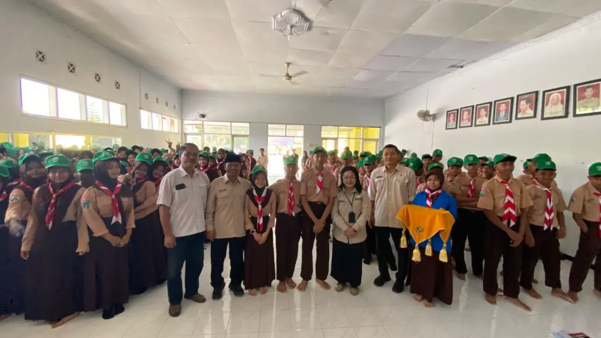 FOTO BERSAMA:  Muhammad Rido’i, S.Pd, M.Pd Kabid Pembinaan SMP pada Kantor Dinas Pendidikan Jember bersama Dwi Kristatiningsih, S.Pd.,M.M. Kepala SMPN 8 Jember saaat foto bersama para Duta Garda 8 Jember. (Jumai/ Radar Jember)
