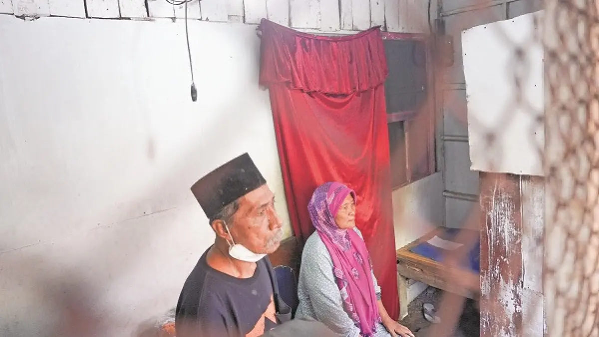 TAK MENYERAH: Misnipah dan suaminya, Nitam, menyeka air matanya karena tak kuasa menahan haru setelah keluarganya mendapat sentuhan hangat dari pemerintah daerah dengan bantuan kesehatan dan hunian hingga kebutuhan sehari-hari. (MAULANA/RADAR JEMBER)