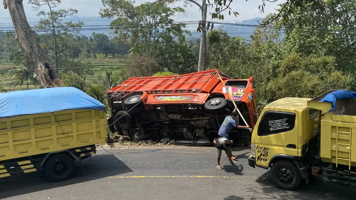 Truk pengangut ikan asin juga terguling di Jalur Gumitir karena menghindari tabrakan dengan truk dari arah berlawanan. (JUMAI/RADAR JEMBER)