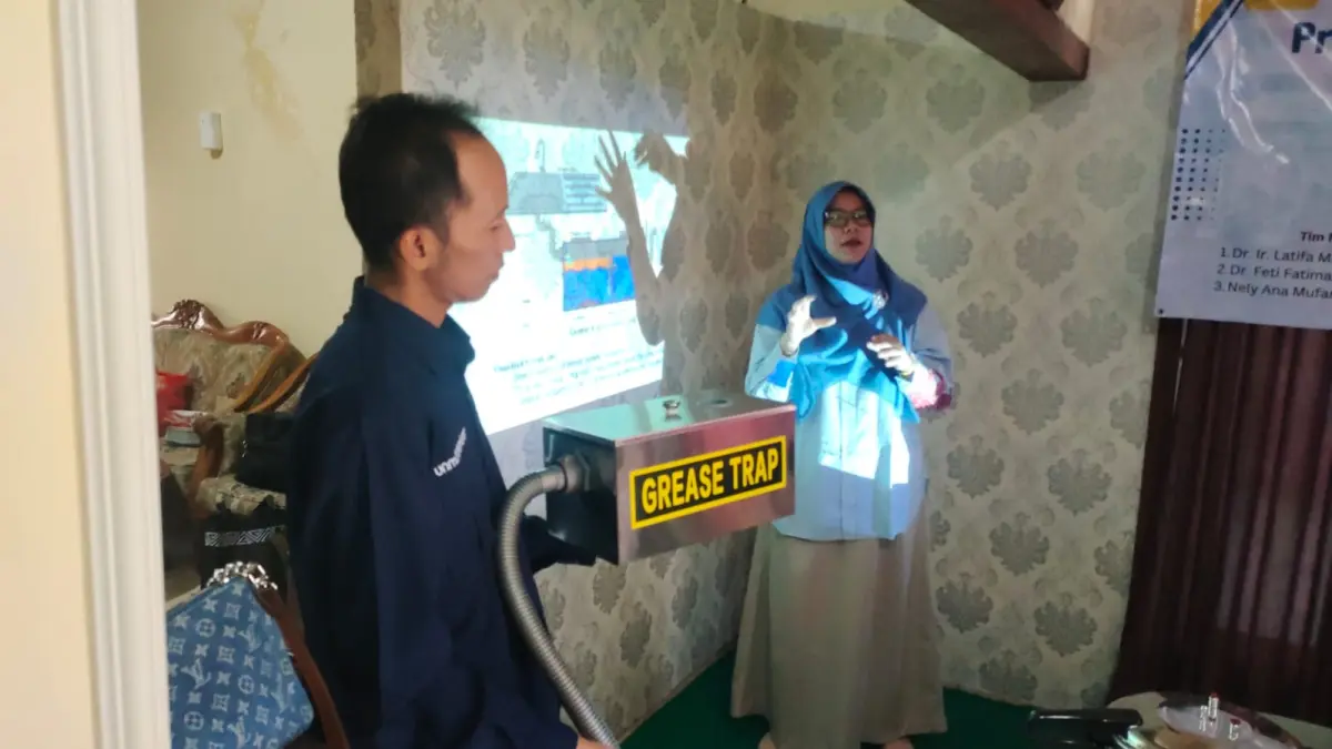 DAMPINGI UMKM: Tim Pengabdian Unmuh Jember menjelaskan cara penggunaan teknologi tepat guna berupa alat pemisah lemak atau grease trap pada UMKM Dapur Shincan