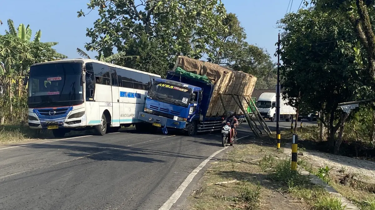 NYARIS TERGULING:&nbsp;Truk tronton bermuatan tripleks nyaris terguling di jalan menikung Desa Garahan, Kecamatan Silo. (JUMAI/RADAR JEMBER)