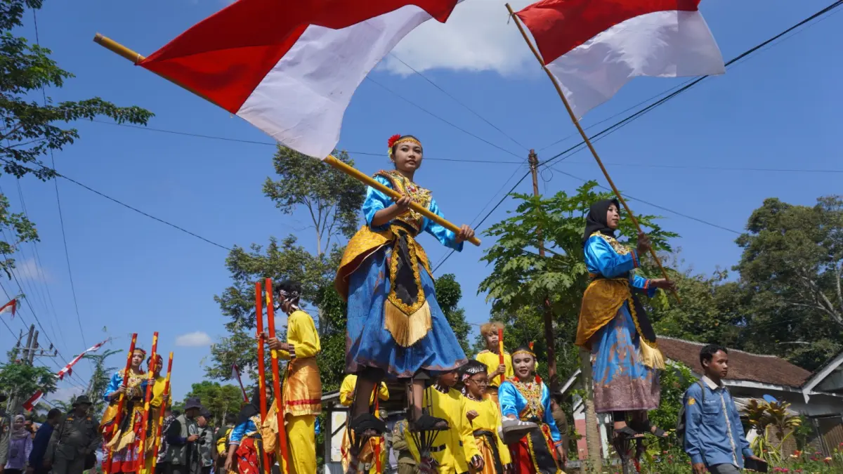 PUKAU PENONTON: Penampilan egrang dan tari-tarian saat Festival Egrang XIII Tanokee, Ledokombo, Jember. (MAULANA/RADAR JEMBER)