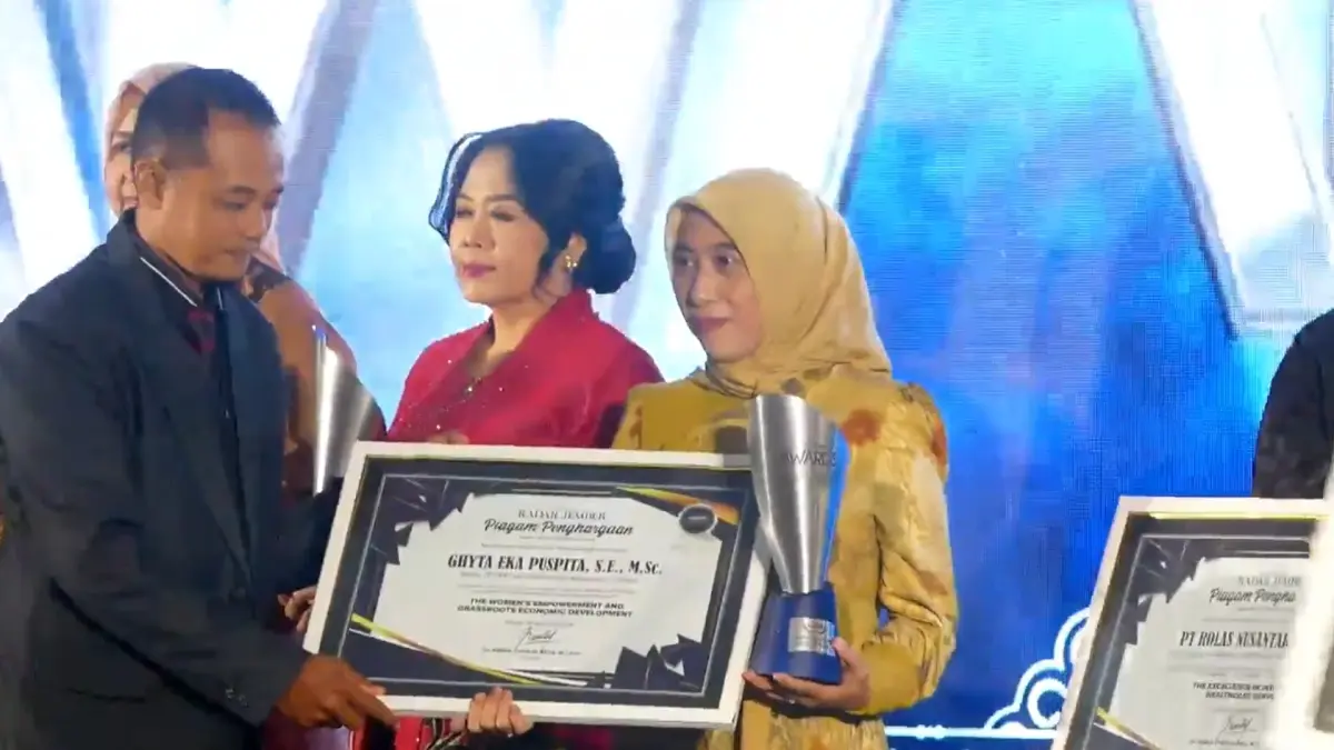 General Manajer Jawa Pos Radar Jember MS. Rasyid, menyerahkan apresiasi penghargaan untuk Ketua Dekranasda Ghyta Eka Puspita, yang saat itu diwakili oleh pengurus Dekranasda, dalam ajang Radar Jember Award 2026, di Hotel Fortuna Jember, (20/8). (Dok. Radar Jember)