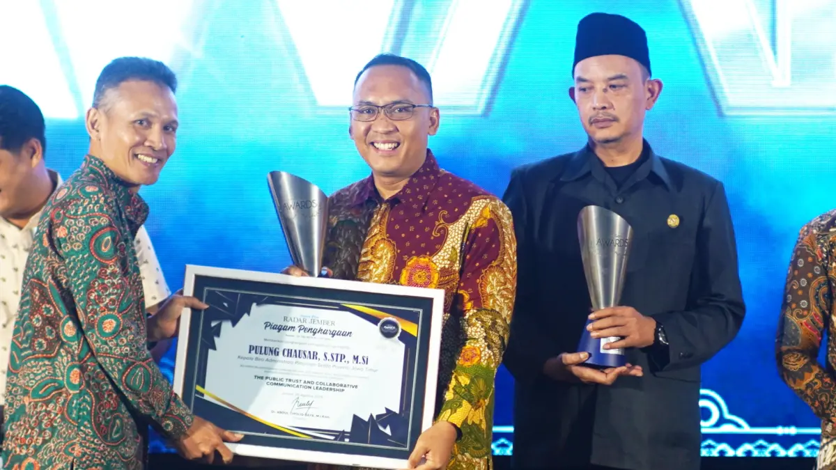 Direktur Jawa Pos Radar Nur Wahid, menyerahkan apresiasi penghargaan untuk Kabiro Adpim Jatim Pulung Chausar, yang saat itu diwakili oleh Biro Adpim Setdaprov Jatim (tengah), dalam ajang Radar Jember Award 2026, di Hotel Fortuna Jember, (20/8). (Dok. Radar Jember)