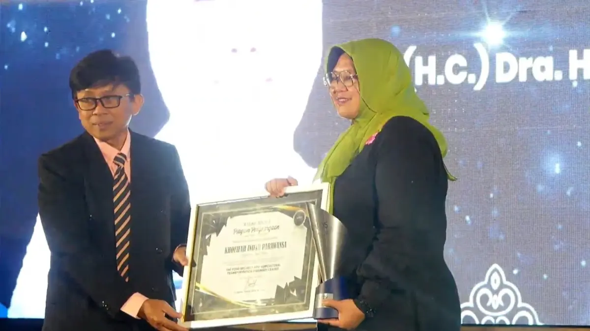 Direktur Jawa Pos Radar Jember Abd. Choliq Baya, menyerahkan apresiasi penghargaan untuk Gubernur Jawa Timur Khofifah Indar Parawansa, yang saat itu diwakili oleh Kadiskominfo Jatim Sherlita Ratna Dewi Agustin, dalam ajang Radar Jember Award 2026, di Hotel Fortuna Jember, (20/8). (Dok. Radar Jember)