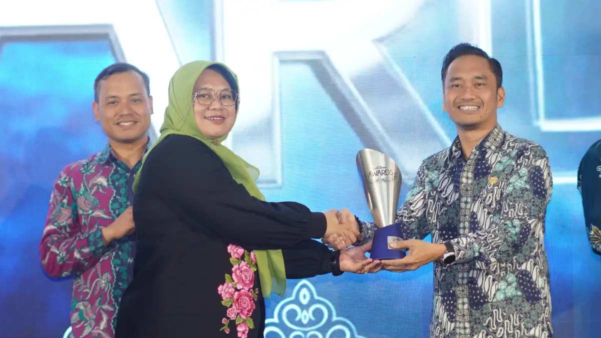 Kepala OJK Jember Aris Budiman menerima penghargaan Radar Jember Awards atas dedikasi OJK dalam memperkuat literasi keuangan di Sekarkijang. (Yulio/FA)