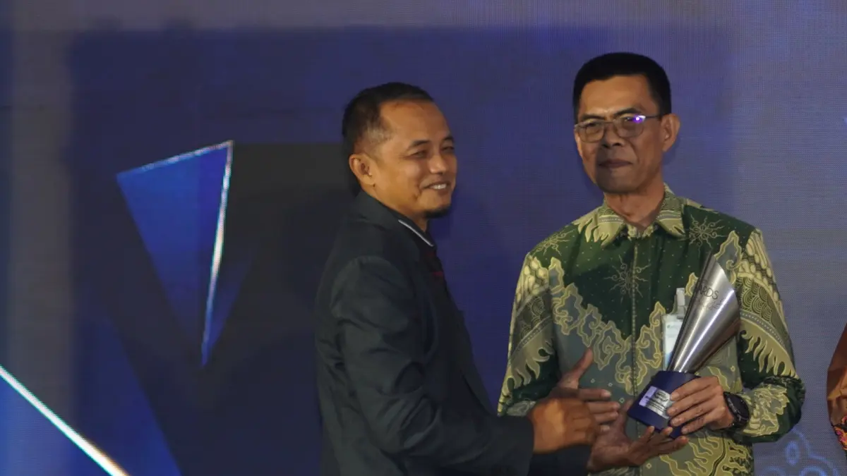 Kepala BPJS Ketenagakerjaan Cabang Jember, Dadang Komarudin (kanan) menerima penghargaan dalam Radar Jember Award 2026
