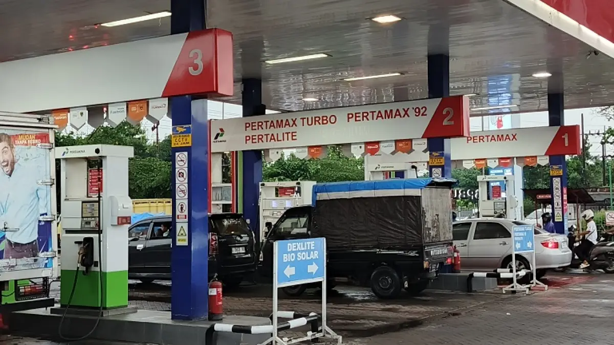 LENGAN: Aktivitas SPBU di Mangli setelah diguyur hujan singkat, kemarin siang (8/9). Hujan yang turun tersebut membuat antrean kendaraan roda memilih pulang dan berteduh. (MAULANA/RADAR JEMBER)
