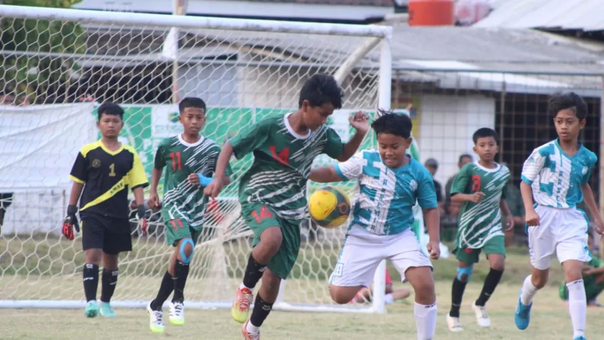 NGEYEL: Pemain SDN Tamansari 1 (hijau) berebut bola dengan pemain MI At Taqwa (Biru) di depan mulut gawang. (ILHAM/RJ)