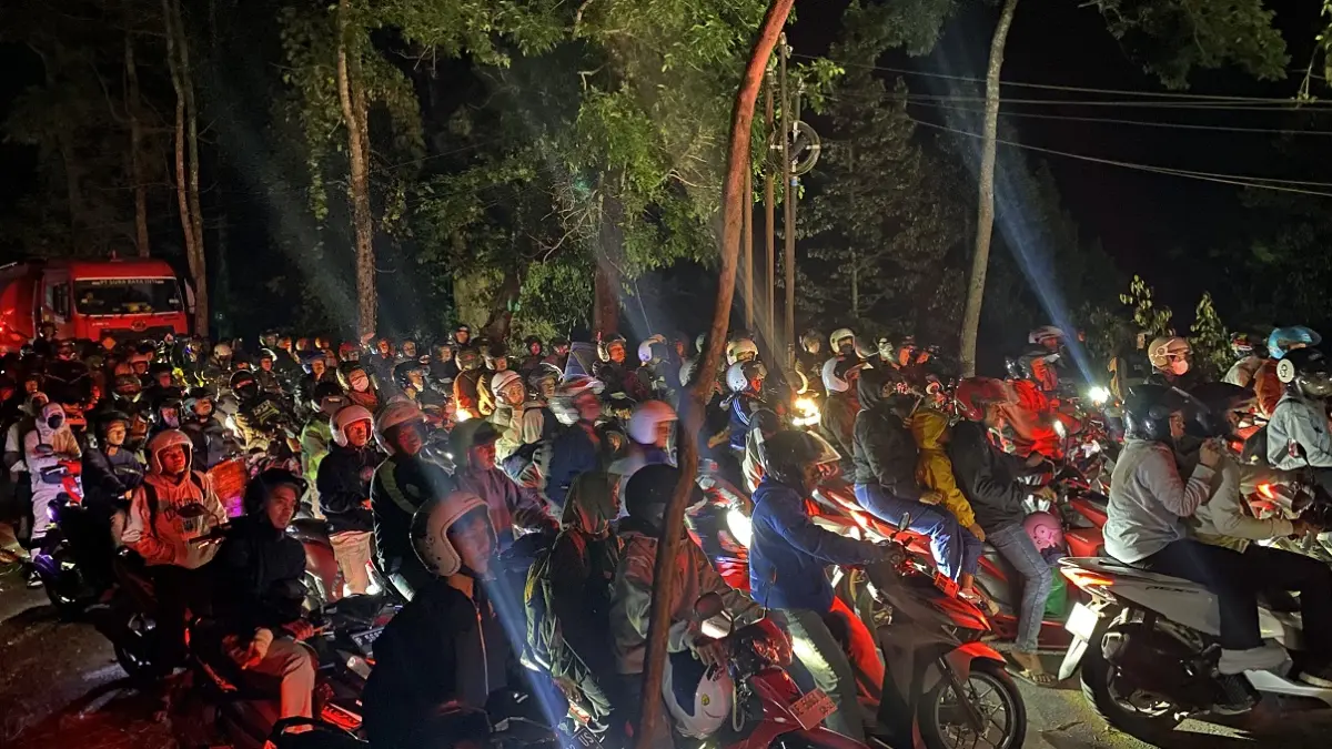 TAK BISA LEWAT: Sejumlah kendaraan roda dua ekstra bersabar menanti evakuasi pohon tumbang di Jalur Gumitir, Minggu (13/9) malam hingga Senin (14/9) dini hari. (JUMAI/RADAR JEMBER)