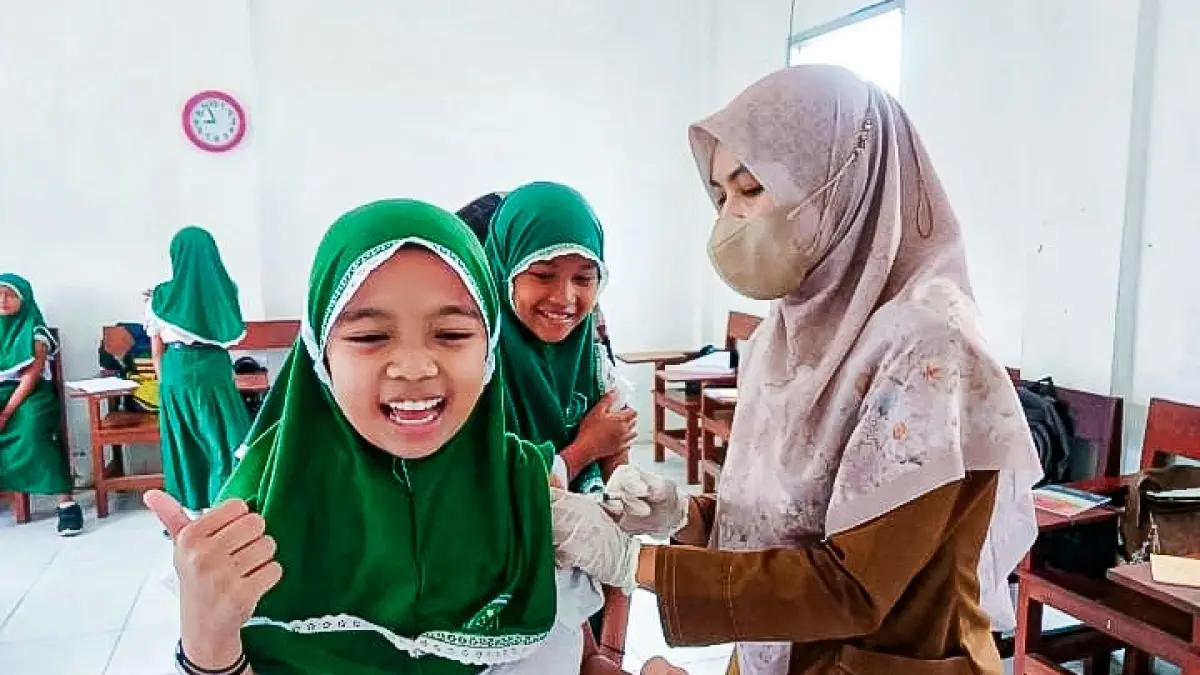 SENANG: Ekspresi siswa MI Alfalah, Kecamatan Kencong yang menunjuk rasa suka cita saat disuntik vaksin, kemarin (15/9). (PPID JEMBER)