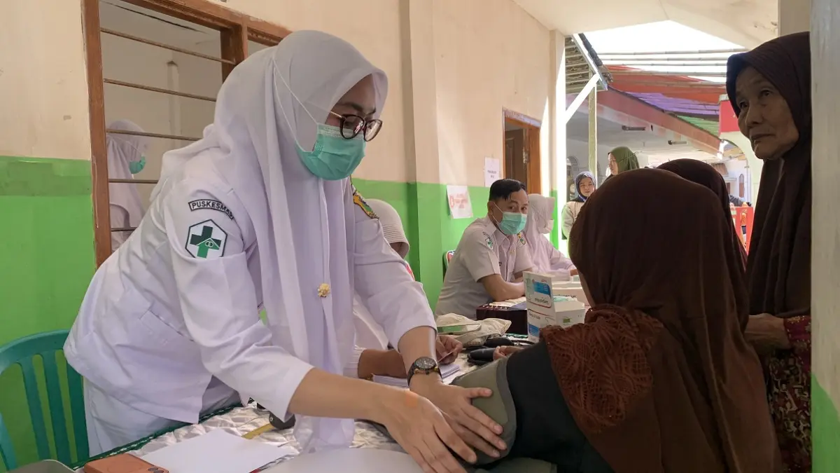 DIPERIKSA: Salah seorang tenaga kesehatan di Bondowoso melakukan pemeriksaan kesehatan warga, dalam rangka cek kesehatan gratis. (ILHAM WAHYUDI/RADAR IJEN)